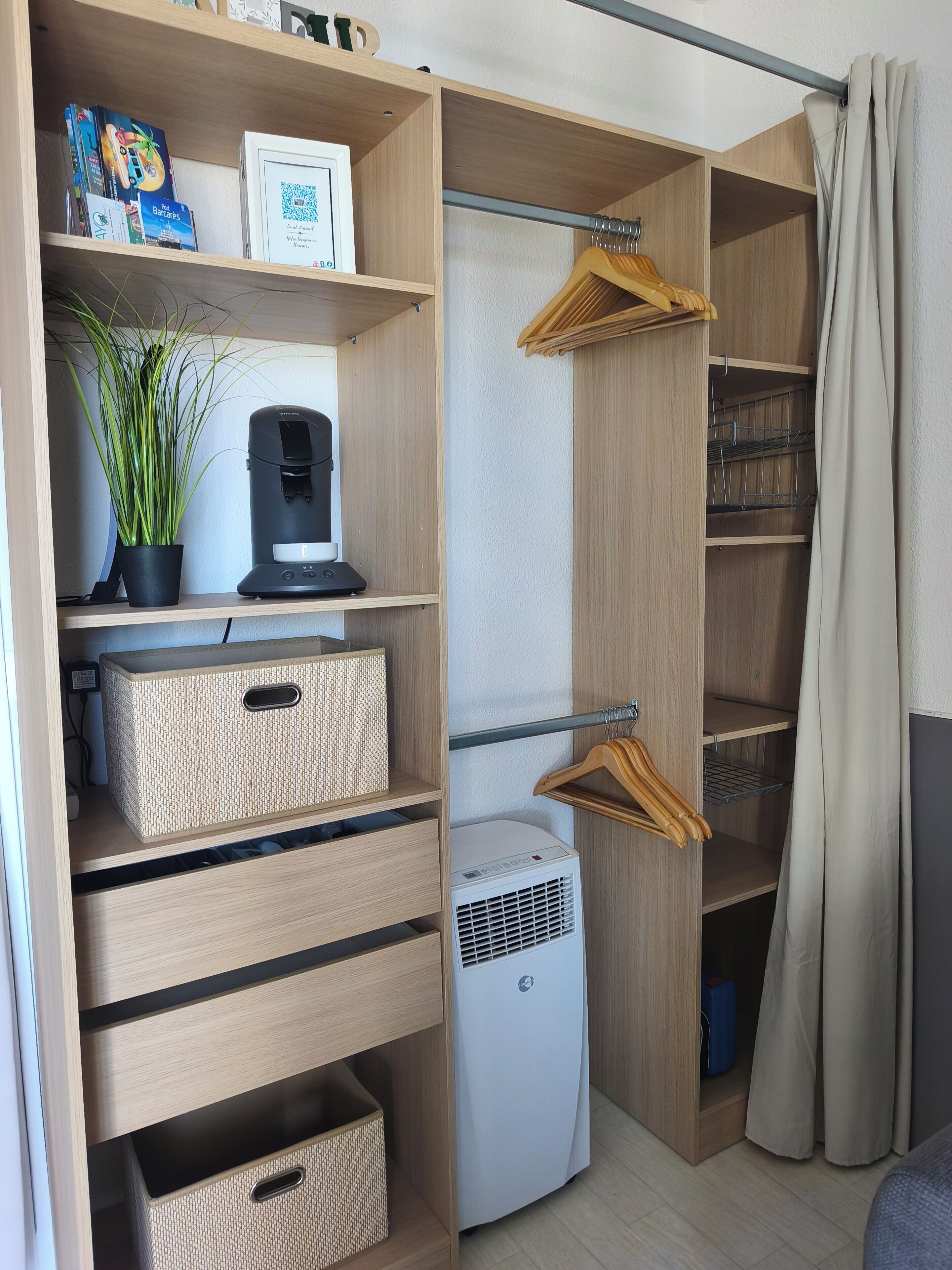 Um closet espaçoso com prateleiras de madeira, uma cafeteira, um vaso de plantas e um purificador de ar branco.