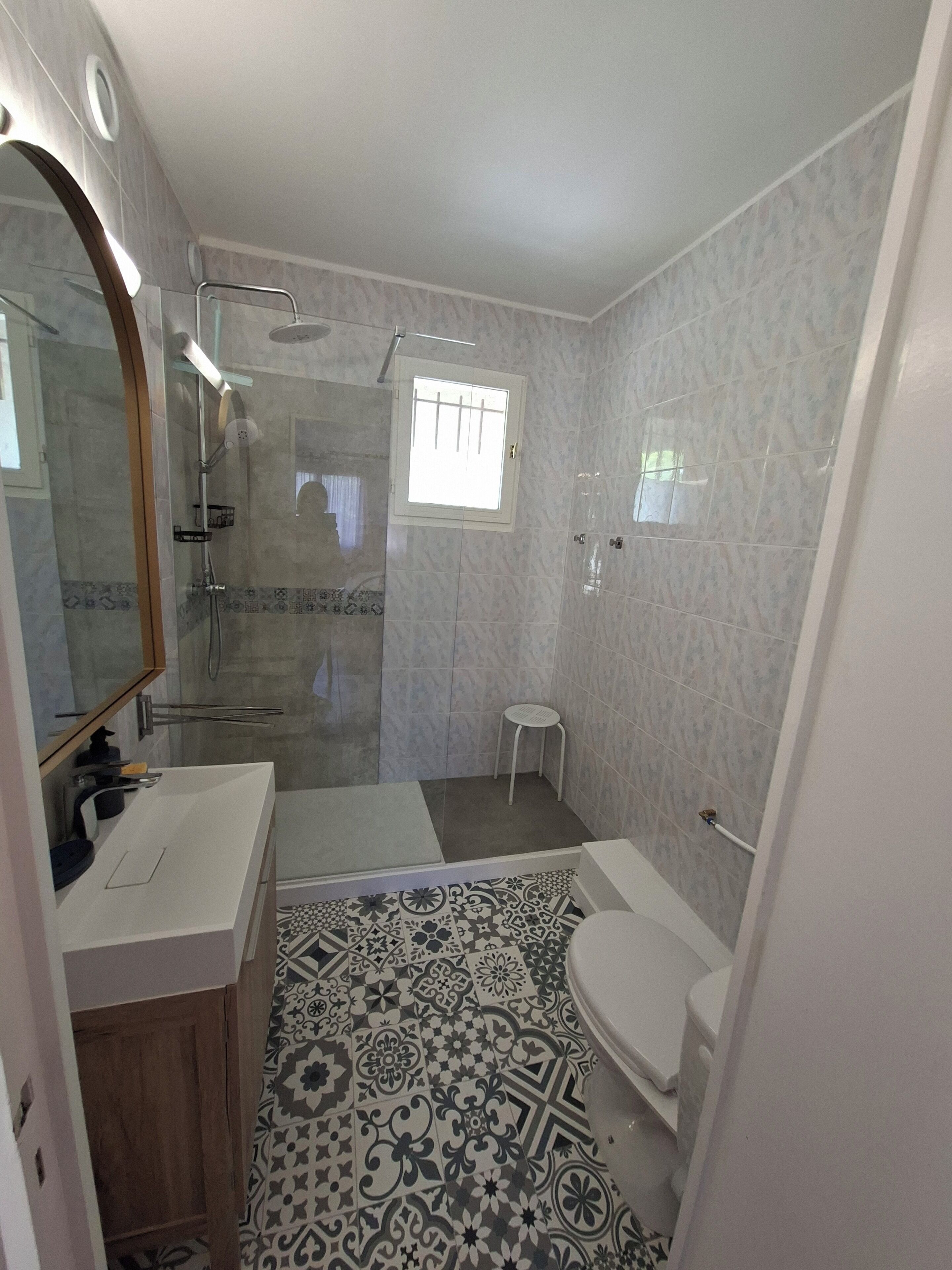 Ein Badezimmer mit Dusche, Toilette und Waschbecken.