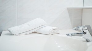 Ein Badezimmer mit Waschbecken, Spiegel und Handtuch.