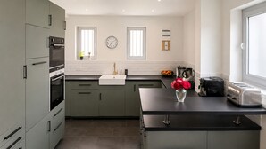 A modern kitchen with a built-in oven, a sink, a clock, and a toaster. - KER MI NAT': A large family home in the heart of Vannes, (Vannes)