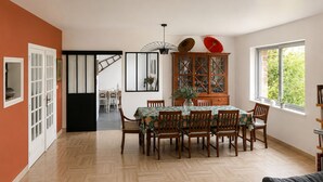 A dining area with a wooden table, chairs, and a cabinet with glass doors. - KER MI NAT': A large family home in the heart of Vannes, (Vannes)