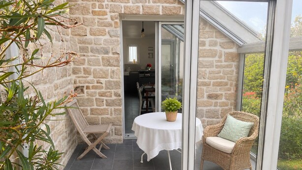A stone-walled patio with a table and chairs, a wicker chair, and a potted plant. - KER MI NAT': A large family home in the heart of Vannes, (Vannes)