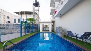 A swimming pool with a metal fence, a small building with a glass door, and a stone wall. - Beautiful Waterfront 4-bedroom Terrace Duplex in vibrant Lekki (Lekki)
