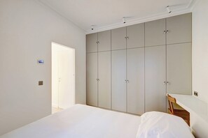 A bedroom with a bed, a wardrobe, a mirror, and a door. - Cozy Appartement a/c 1br/2p- Montmartre (Paris)