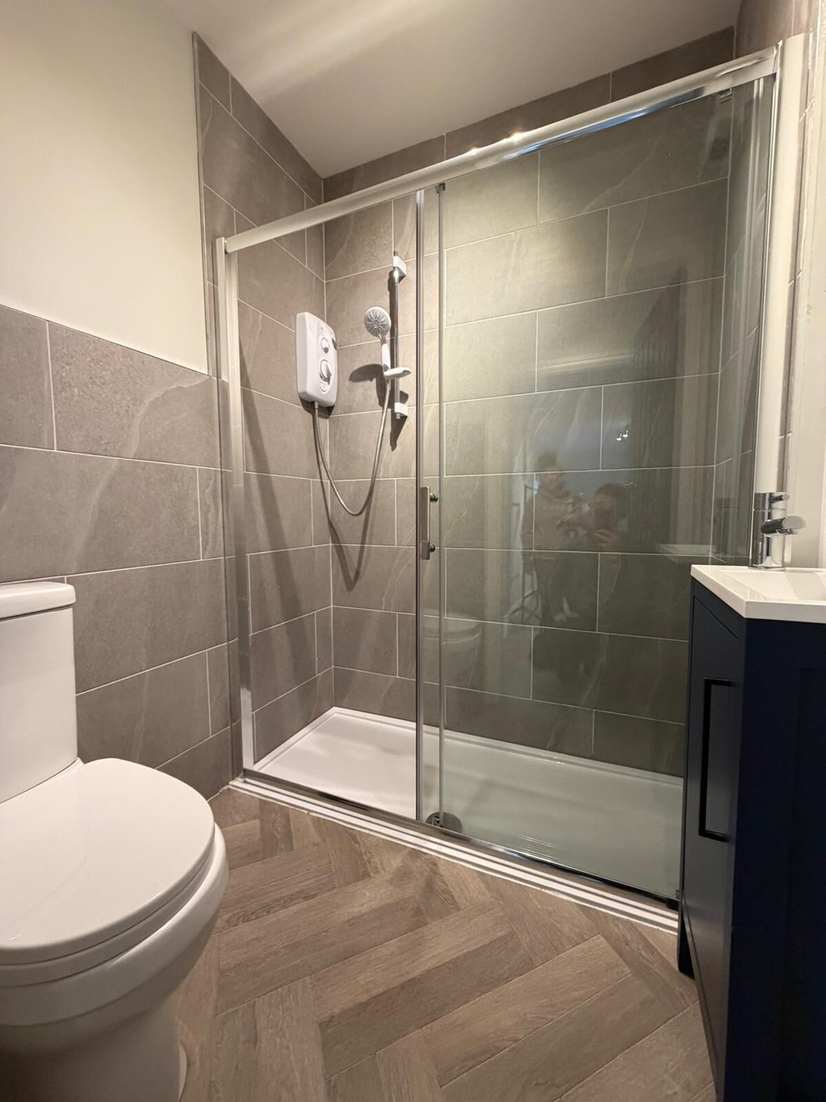 A modern bathroom with a shower, toilet, and vanity.