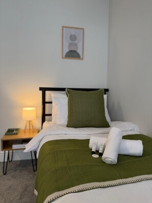 Tabla de planchar con plancha y ropa de cama 