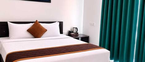 Una habitación de hotel con una cama, un cuadro, un aire acondicionado y cortinas.