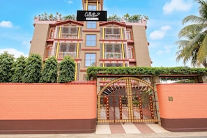A multi-story building with a sign indicating it is serviced by OYO. - Classic Cherry City Cottage (Guwahati)