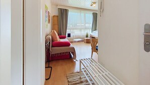 Una sala moderna con un sofá, una mesita y una ventana con cortinas.