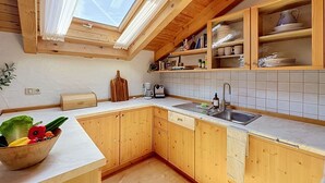 Eine Küche mit Holzausstattung, einer eingebauten Spüle und einem Fenster über der Arbeitsfläche.