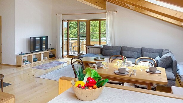 Ein großzügiges Loft mit Essbereich, einer Couch und einem Fernseher.