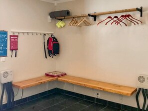 A corner room with a bench, a wall-mounted rack with hangers, a fan, and a small table. - 9 Person Holiday Home in Tanndalen (Tanndalen)