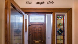 A wooden door with a sign above it, a glass door to the left, and a stained glass window to the right. - Beautiful  villa for 8 guests with WIFI and TV (Lossiemouth)