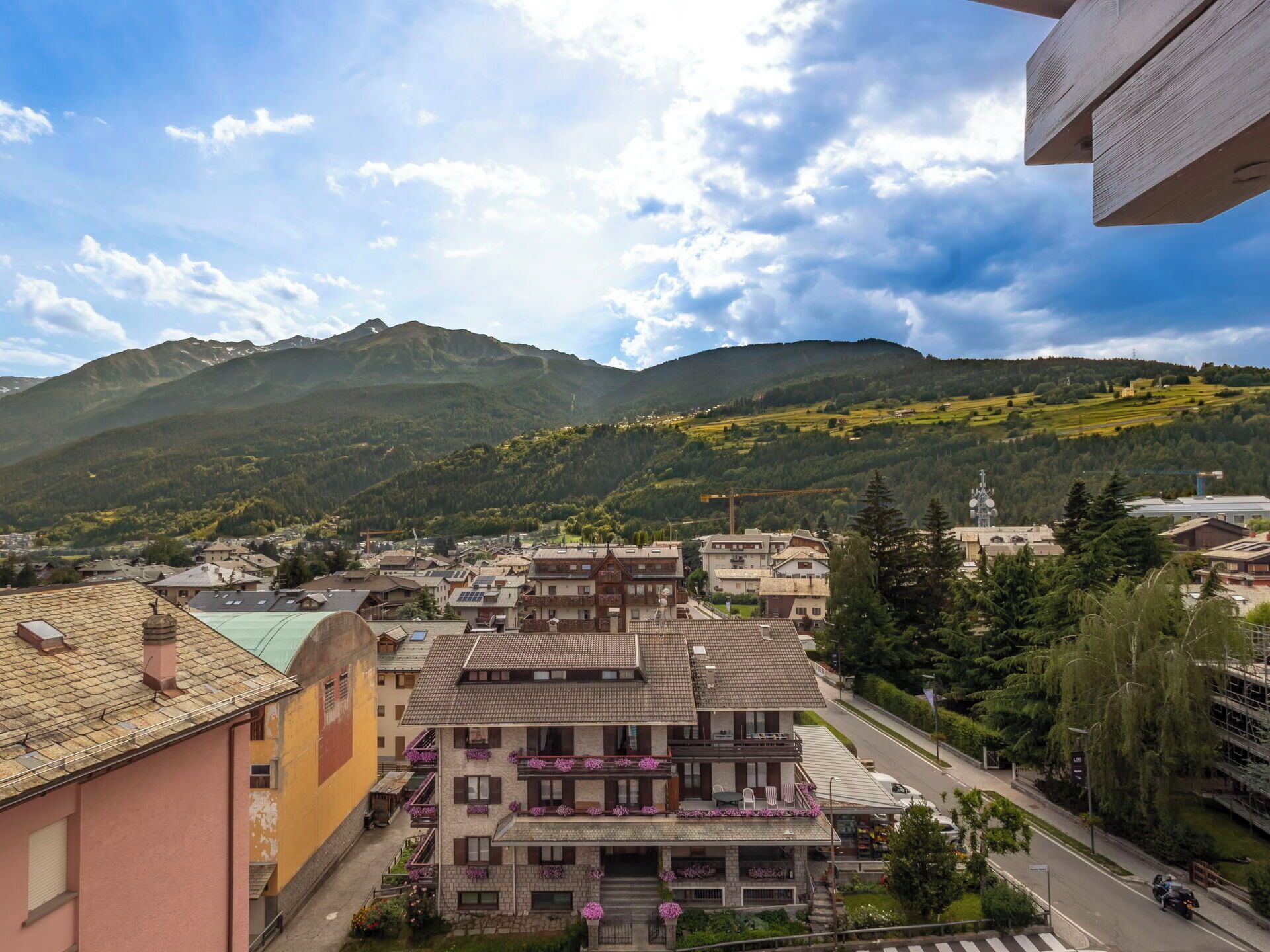 A town with buildings, a road, and mountains in the background.
