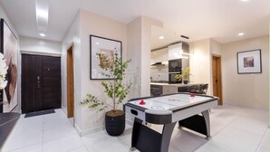 Un salon moderne comprenant une table de billard, un coin cuisine et un espace repas.