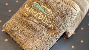 A folded towel with embroidered text on a dark fabric with star patterns.