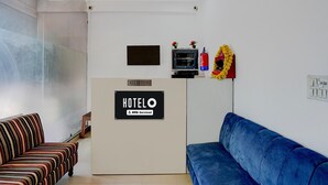 A reception area with a reception desk, a TV, and a fire extinguisher. - Classic Gomti Nagar Station (Lucknow)