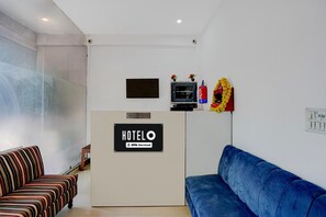 Ein Empfangsbereich mit Empfangstresen, einem Fernseher und einem Feuerlöscher.
