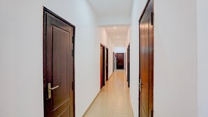A corridor with wooden doors and white walls. - Classic Gomti Nagar Station (Lucknow)