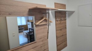 A room with a mirror, a wooden wall, a white wardrobe, and a hanging coat rack. - LUFT Apartment in Kritzendorf/Klosterneuburg near Vienna, with parking (Klosterneuburg)