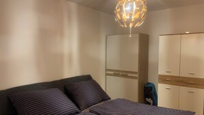 A bedroom with a bed, a wardrobe, and a hanging light fixture. - LUFT Apartment in Kritzendorf/Klosterneuburg near Vienna, with parking (Klosterneuburg)