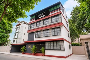 Un edificio de varios pisos con balcones, una señal que indica que es administrado por OYO, y un diseño arquitectónico moderno.