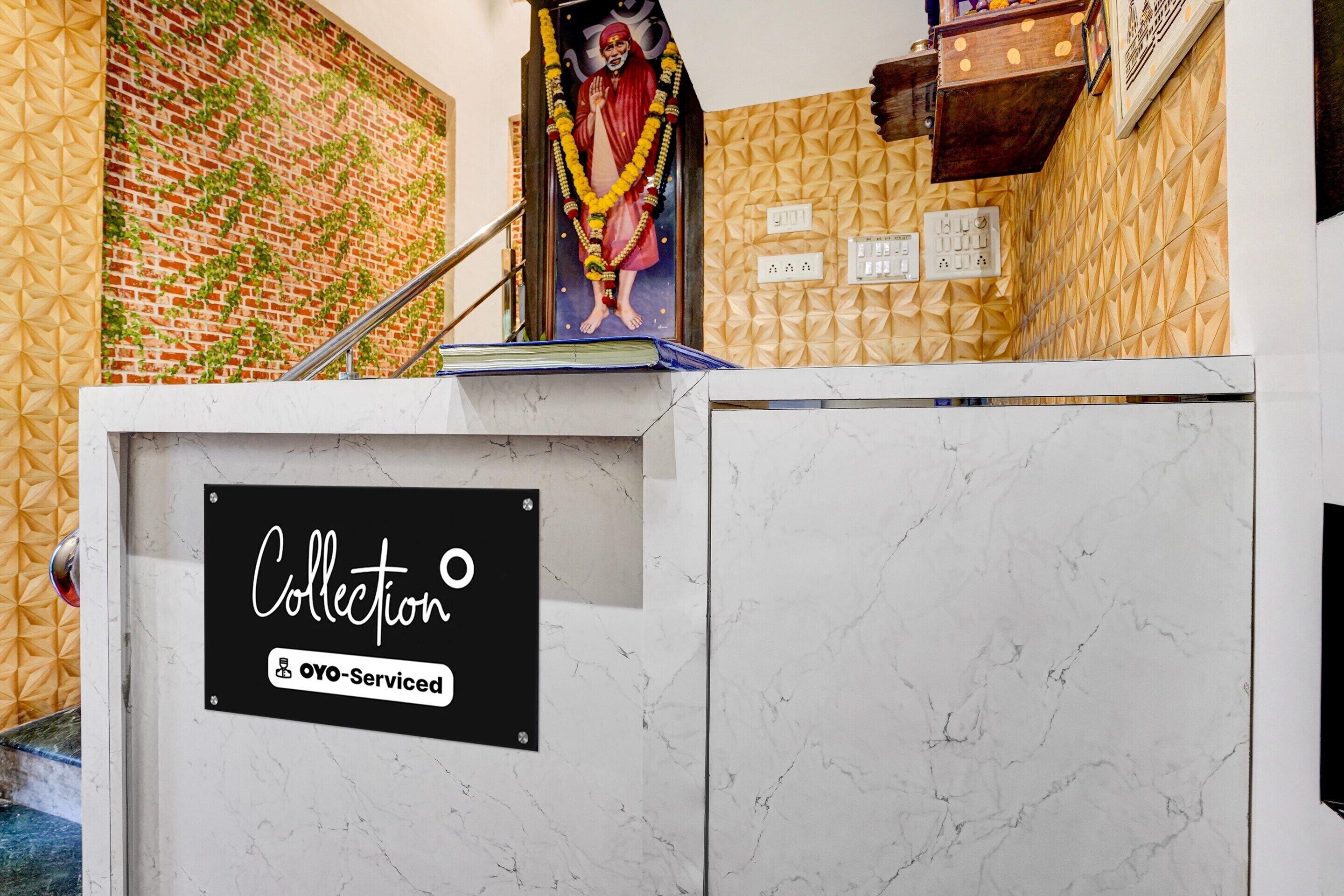 A reception desk with a sign indicating it is a collection point for OYO-Serviced guests.