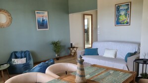 Un saló amb un sofà, cadires, una taula de centre i obra d'art a les parets.