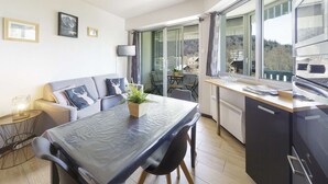 Uma cozinha moderna com uma mesa de jantar, cadeiras e vista para o exterior.