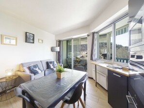 A modern kitchen with a dining table, chairs, and a view of the outdoors. - Renovated apartment station view - 4 guests (Gourette)