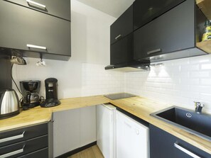 A compact kitchen with a coffee maker, a kettle, and a dishwasher. - Renovated apartment station view - 4 guests (Gourette)