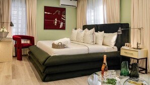 Ein Schlafzimmer mit einem Bett, einem roten Sessel, einem Nachttisch mit Lampe und einer Wand-Klimaanlage.