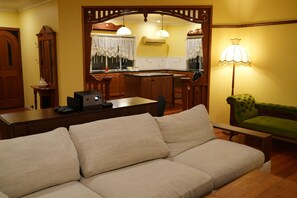 Una sala de estar con un sofá, una mesa de centro, una lámpara y un televisor.