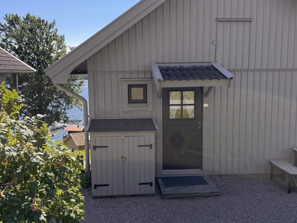 A building with a sloped roof, a door with a window, and a small porch area. - 4 Star Holiday Home in Uddevalla (Uddevalla)