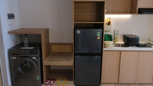Cocina compacta con lavadora, refrigerador y lavamanos.
