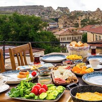 A table set with various dishes and a view of a mountainous landscape.