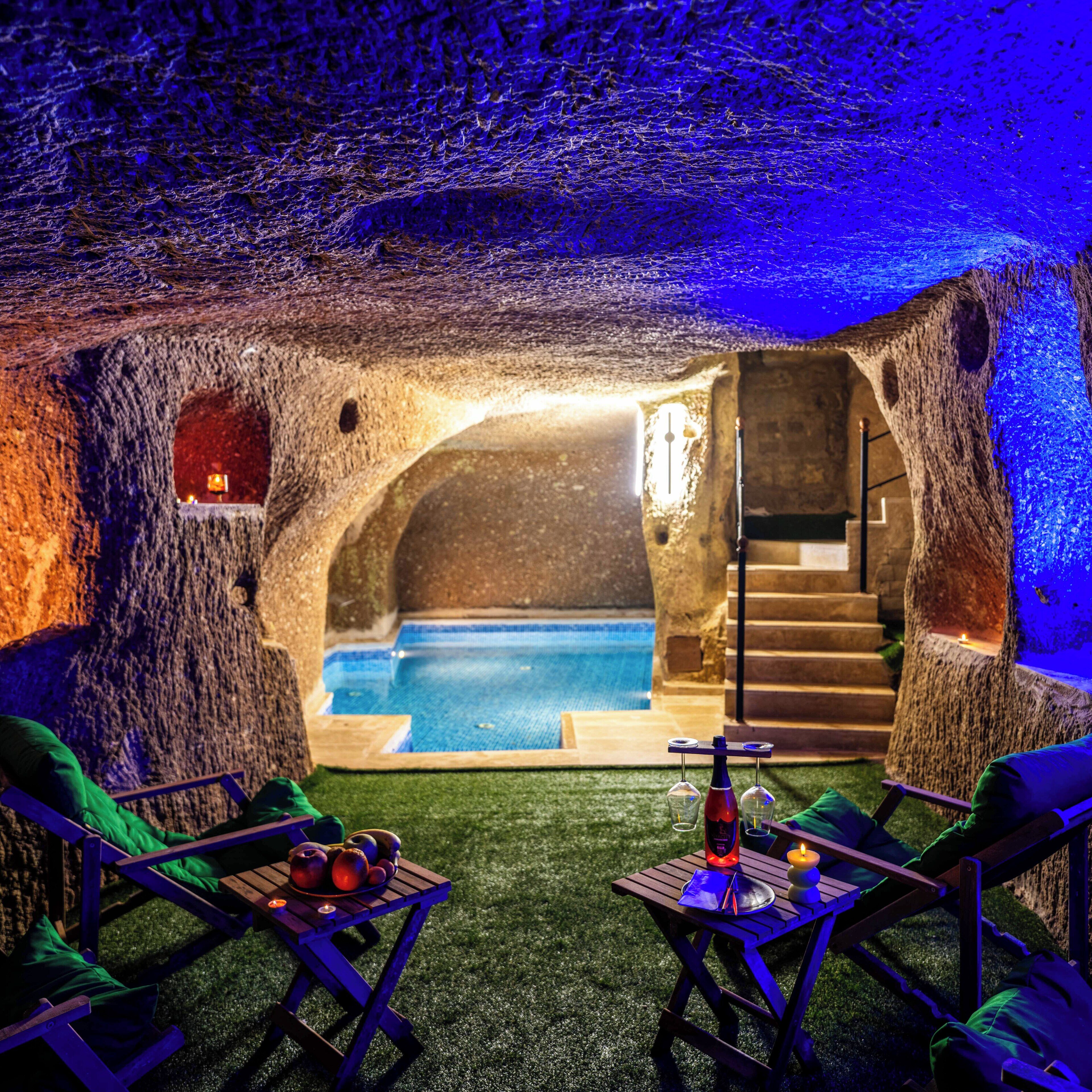 Um interior acolhedor com piscina, móveis de madeira e escada que leva a um andar superior.
