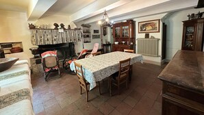 Comedor con una mesa, sillas, chimenea y un armario.