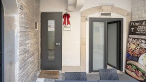 A hotel entrance with a door, a welcome mat, and a signboard.