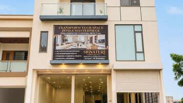 A modern building with a signboard advertising construction services.