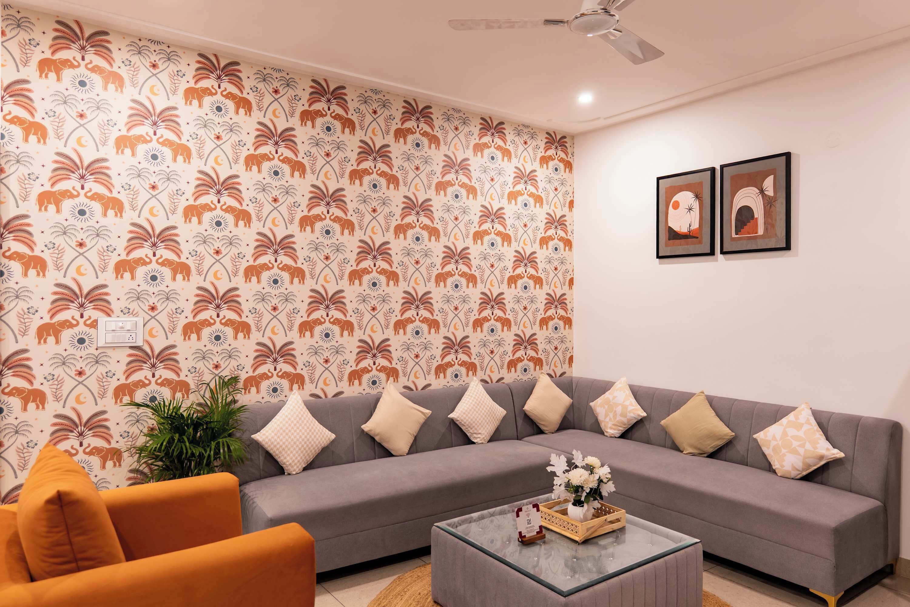 A living room with a grey sofa, orange armchair, and a coffee table with a vase of flowers.