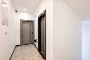 A hallway with a door labeled '301' and a black-framed elevator on the right.