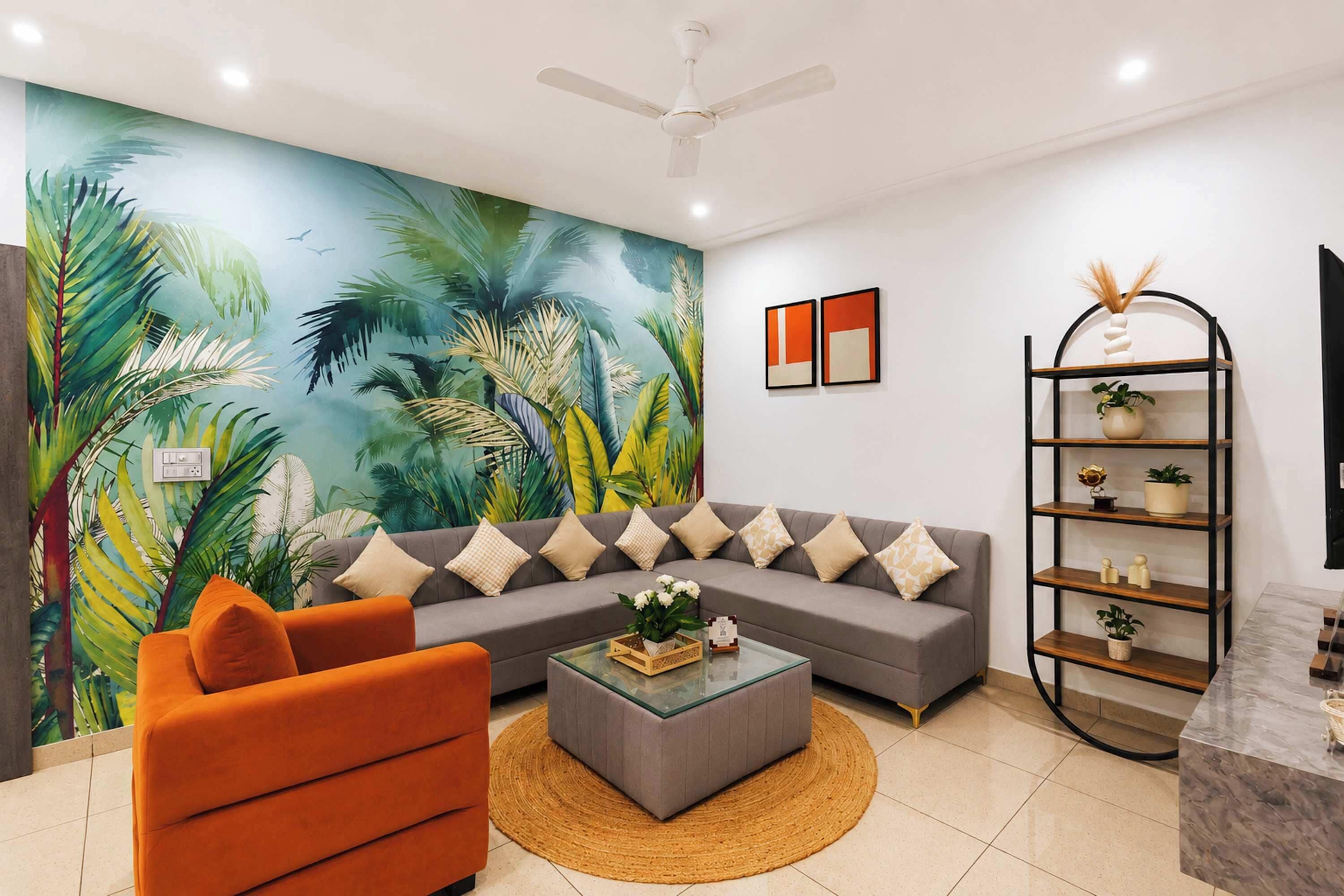 A modern living room with a grey sofa, orange armchair, and a large tropical mural.