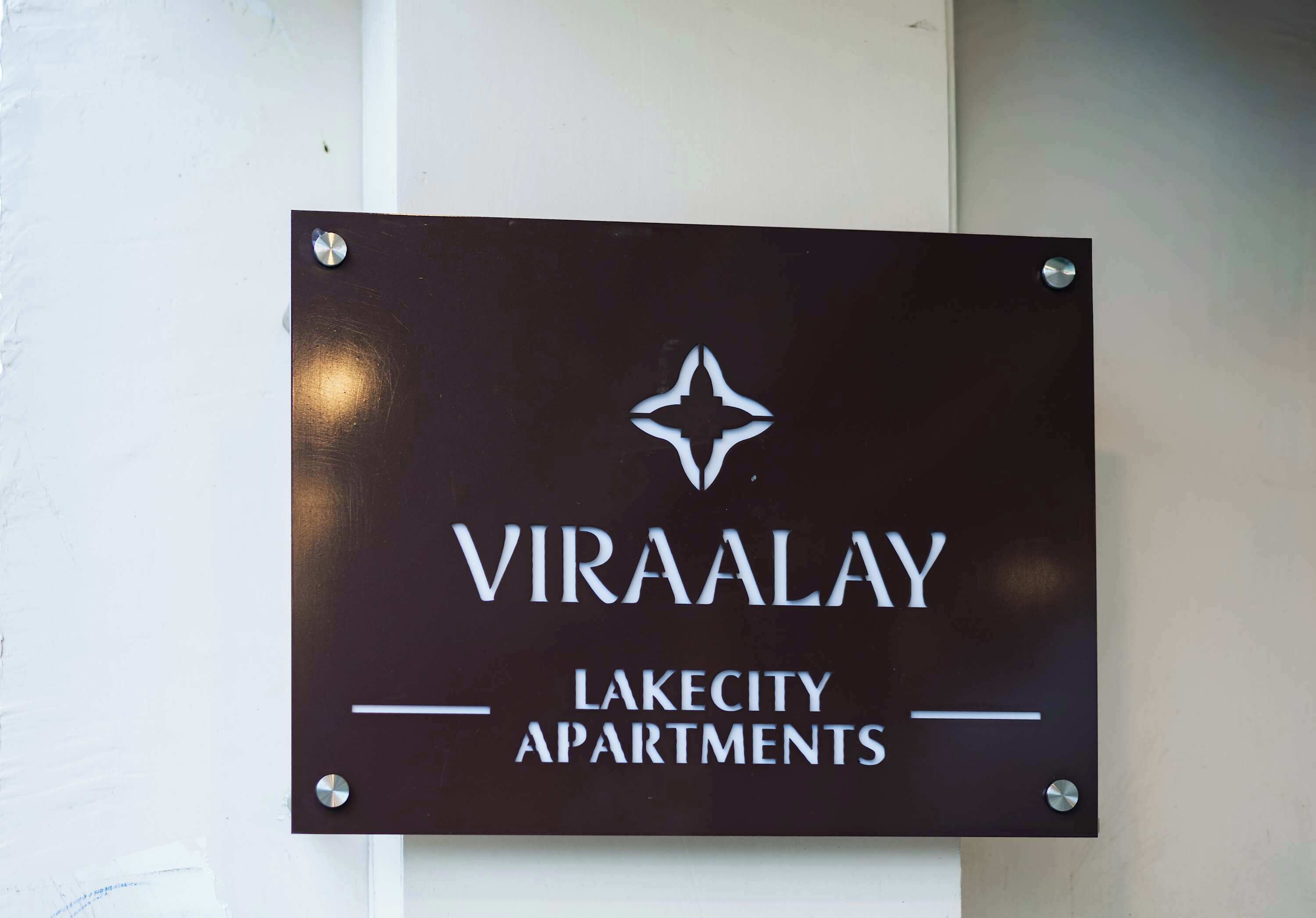 A sign for 'Viraalay Lakecity Apartments' with a star logo.