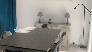 A dining area with a table, chairs, a lamp, a small plant, and a mirror on the wall. - A house in the heart of the vineyards and at the foot of Mont Ventoux (Mormoiron)