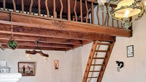 A cozy living room with a wooden ceiling, a sofa, a small table, and a ladder. - Dolus d'Oléron House - Sleeps 7 - Spacious and peaceful, ideal for a family vacation (Dolus-d'Oléron)