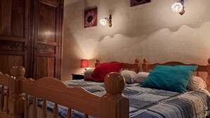 A bedroom with a wooden bed, a nightstand with a lamp, and a wardrobe. - Dolus d'Oléron House - Sleeps 7 - Spacious and peaceful, ideal for a family vacation (Dolus-d'Oléron)