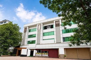 Um edifício moderno com uma placa que diz 'Collection' e uma grande árvore na frente.