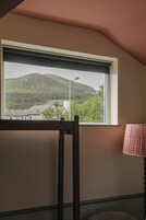 Una habitación con ventana que da a un paisaje montañoso.