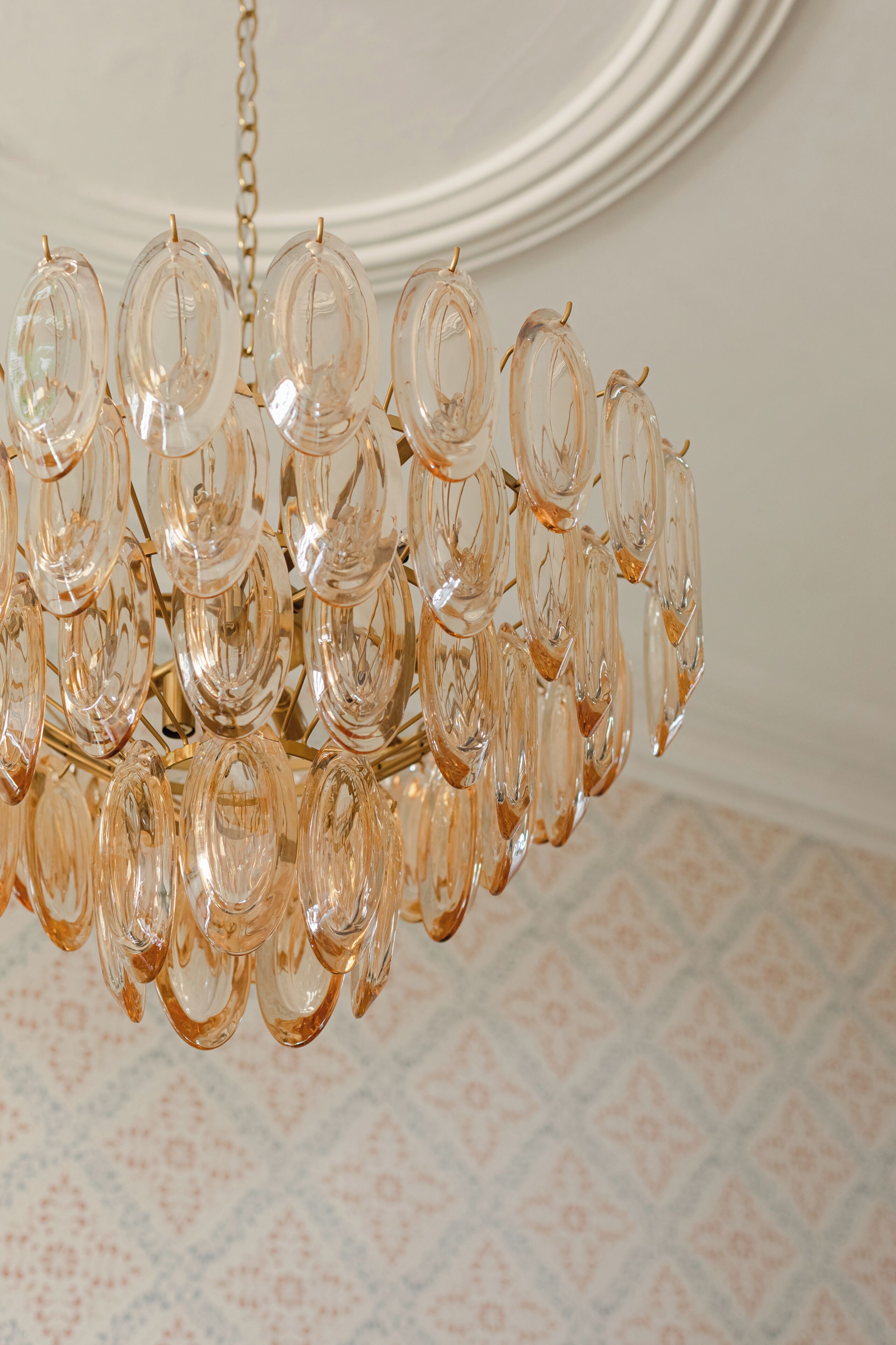 A chandelier with multiple glass elements hanging from a gold chain.